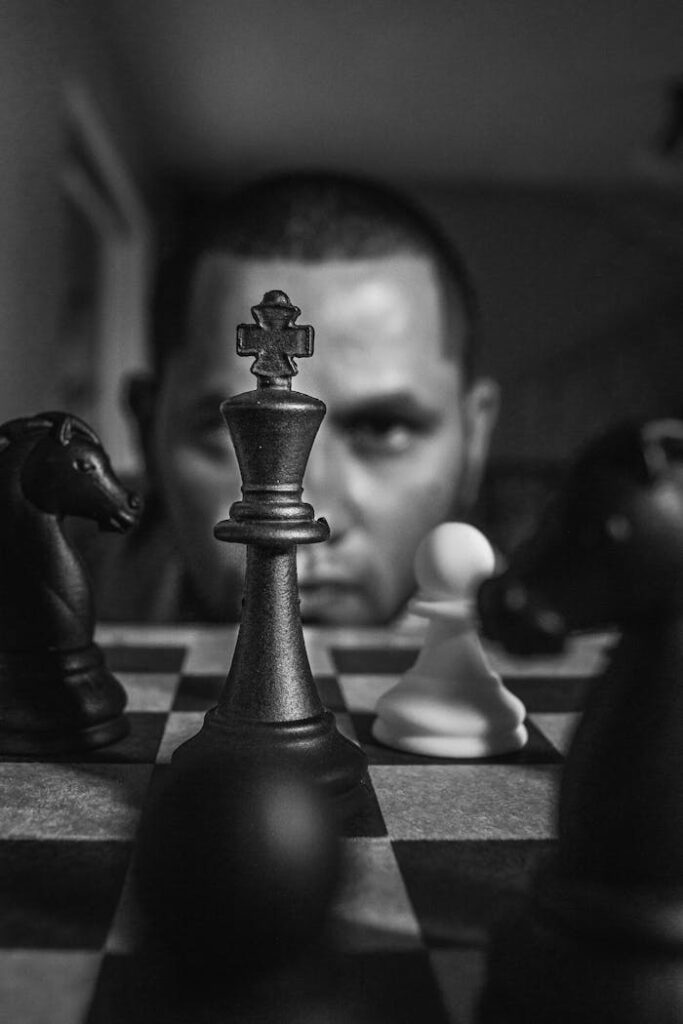 A thoughtful player examines a chessboard, highlighting the strategic complexity of the game.